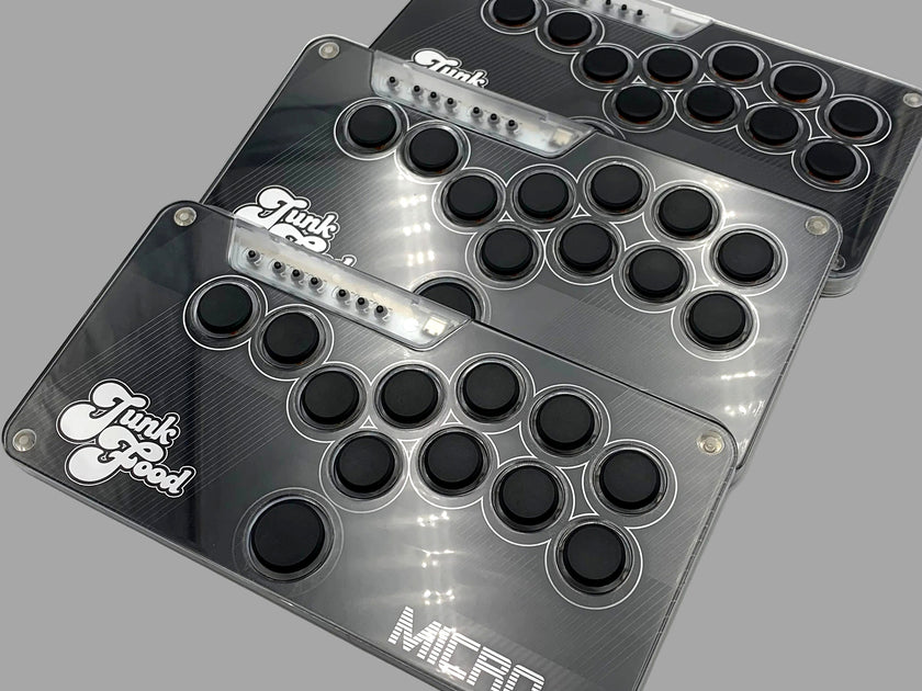 Three Snack Box MICRO leverless FGC fight stick controllers with JunkFood artwork stacked at an angle