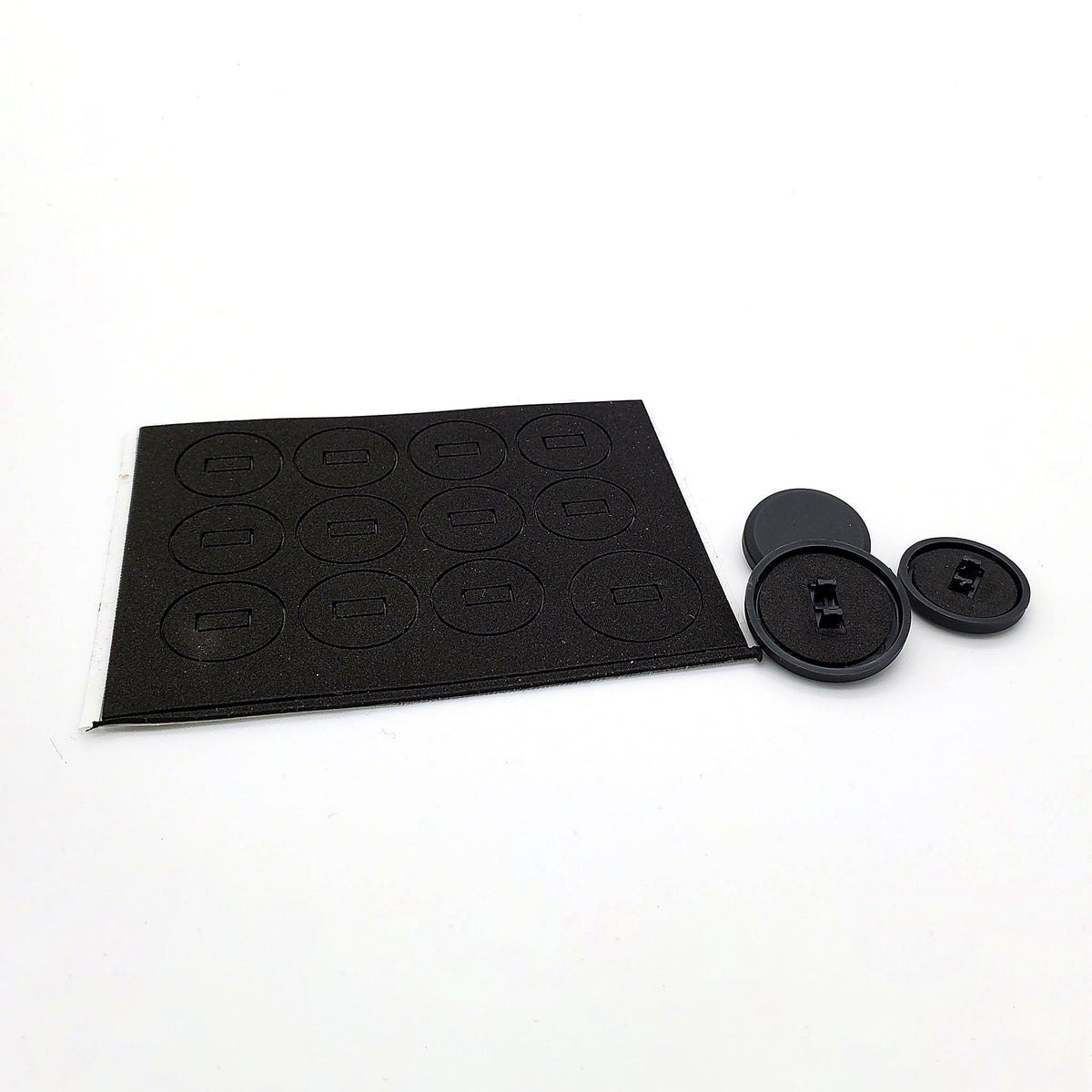 Set of 12 button silencing pads on a foam sheet beside three black keycaps for the Snack Box MICRO leverless FGC fight stick controller